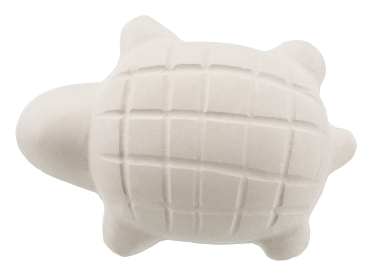 Weiße, schildkrötenförmige Seifenfigur mit Konturenlinien auf dem Panzer, auf hellem Hintergrund.