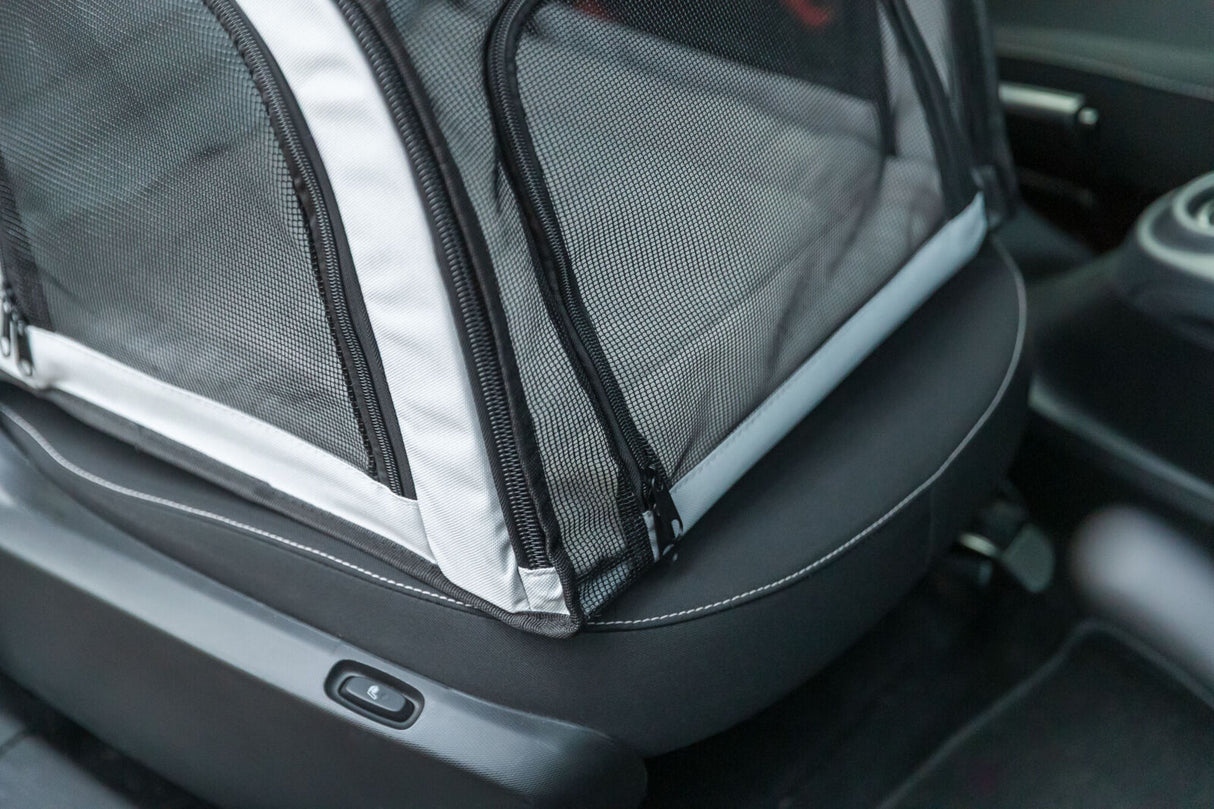 Transportsitz mit schwarzem Netzbezug und Reißverschlüssen auf Autositzen.