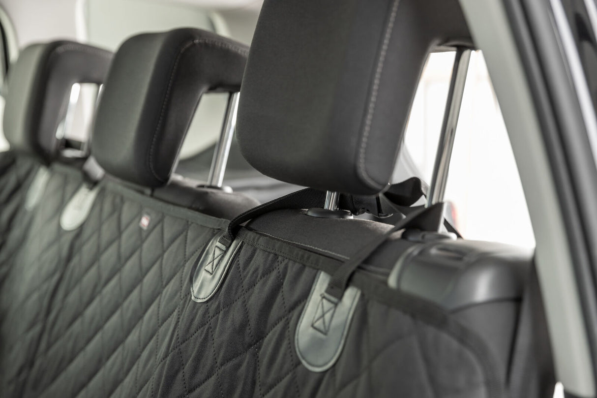 Gepolsterte schwarze Autositzabdeckung mit Riemen und Kopfstützen in einem Fahrzeug installiert.