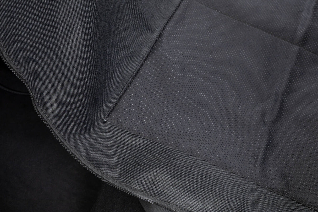 Schwarze Stoffoberfläche mit feiner Textur und sichtbaren Nähten.