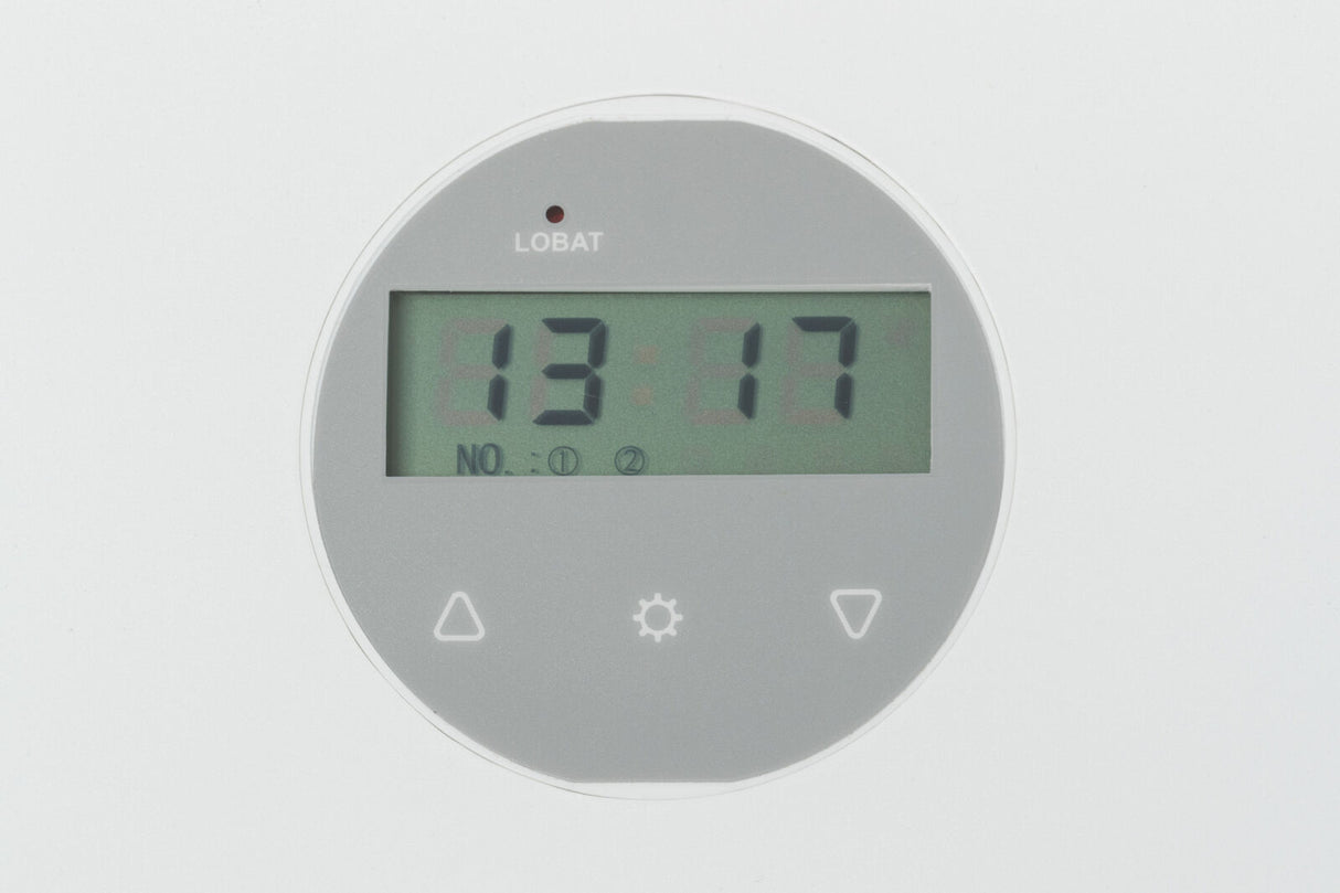 Rundes digitales Display mit grauem Hintergrund, zeigt die Uhrzeit 13:17 und an der Oberseite das Wort "LOBAT".