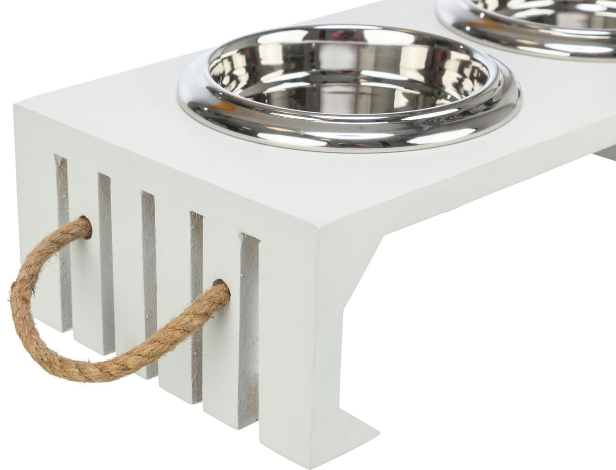 Weiße Futterstation mit zwei runden, silbernen Metallschalen und seitlichem Seilgriff aus Naturfaser.