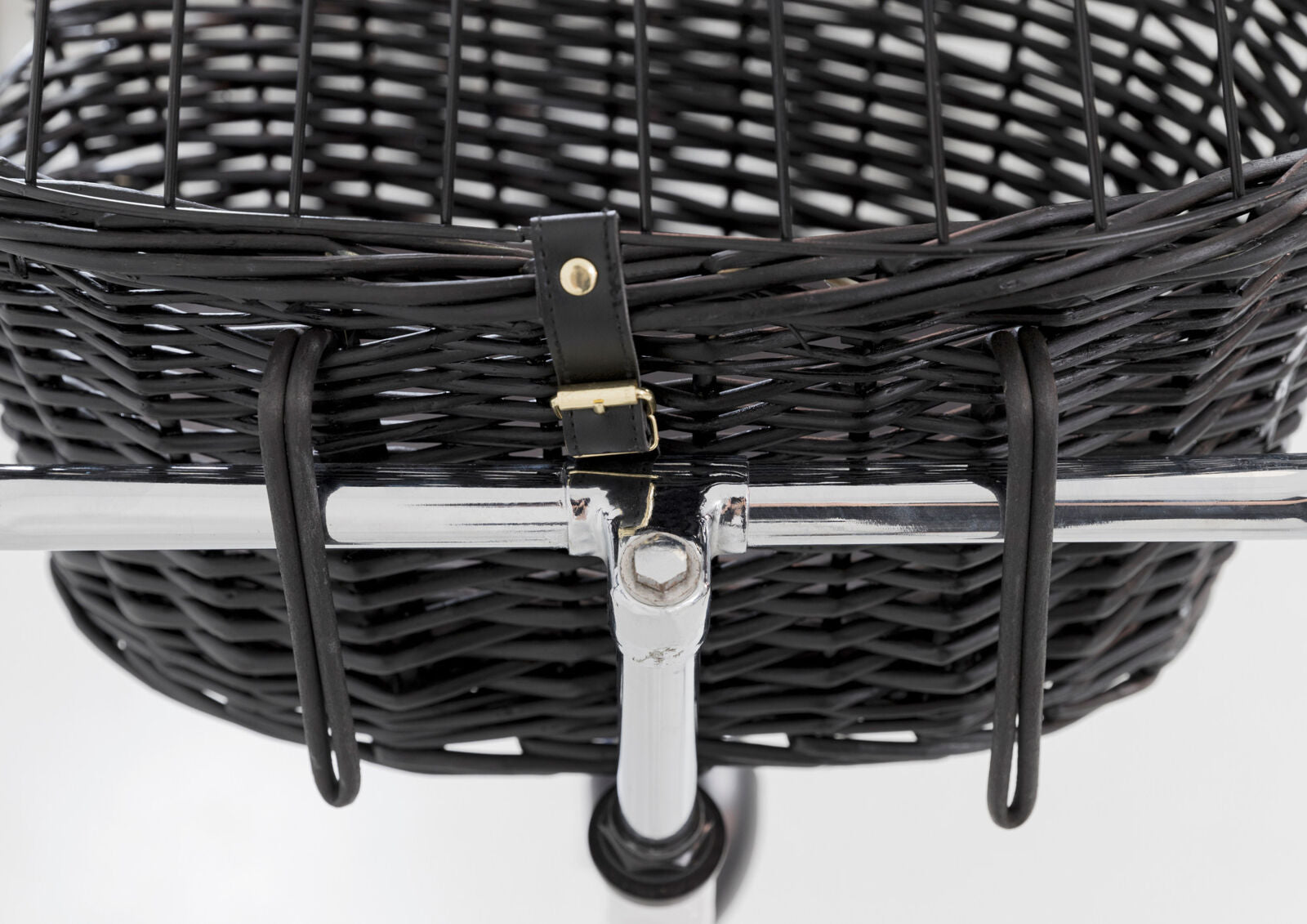 Schwarzer geflochtener Korb mit Metallhalterung und Lederriemen auf einem silbernen Gestell befestigt.