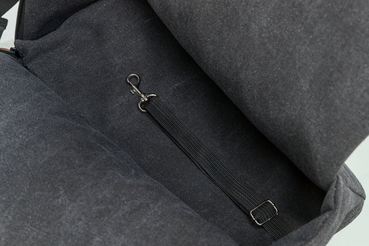 Innenbereich einer dunkelgrauen Tasche mit einem Nylongurt, der an einem kleinen Metallhaken befestigt ist.