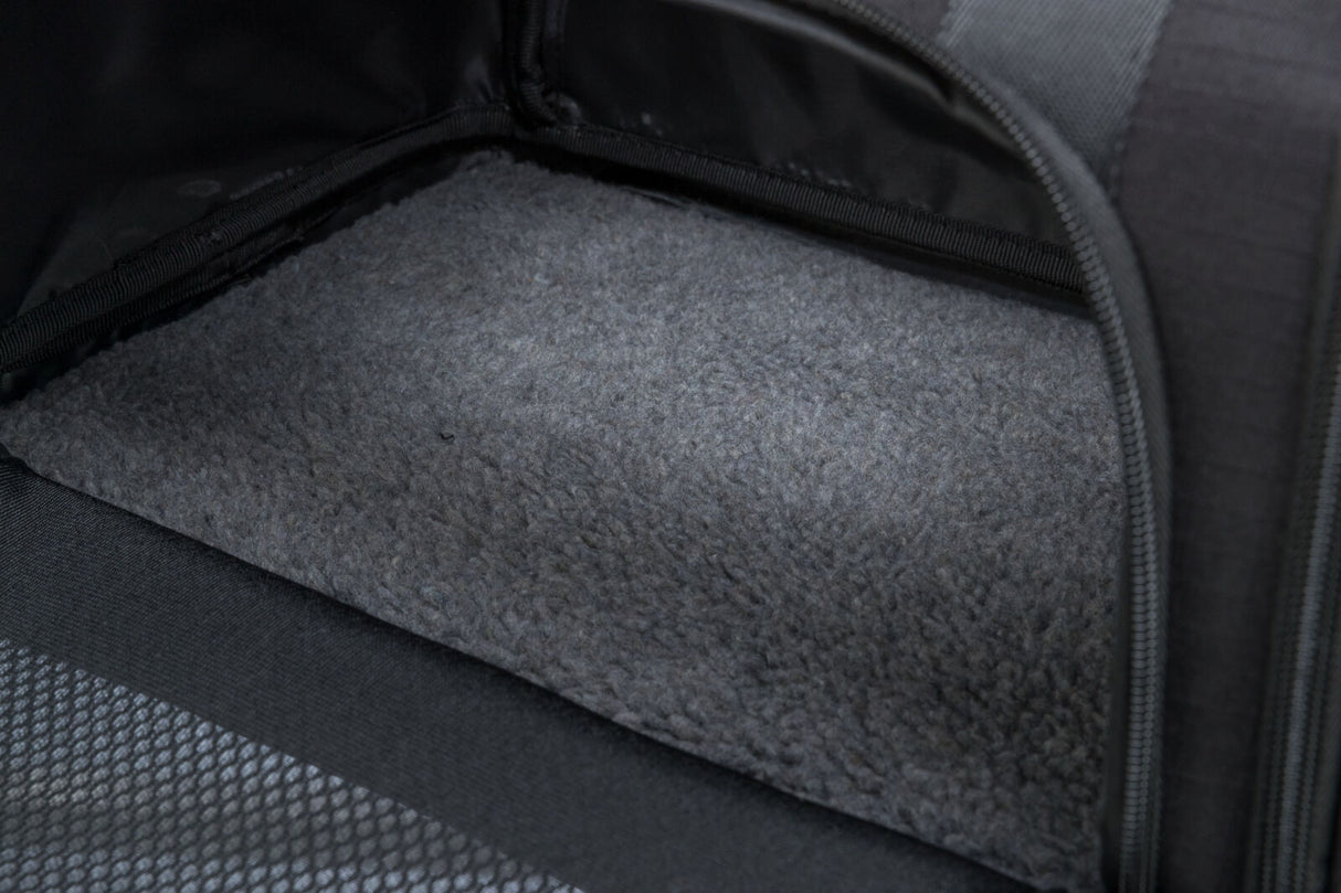 Innenansicht einer schwarzen Tasche mit grauem, texturiertem Boden und Reißverschluss an der Seite.