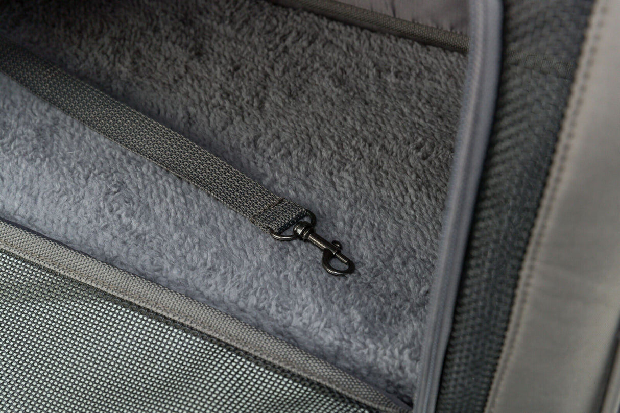 Innenansicht eines grauen, pelzigen Innenfutters mit einem befestigten Gurtband und einem Hakenverschluss.