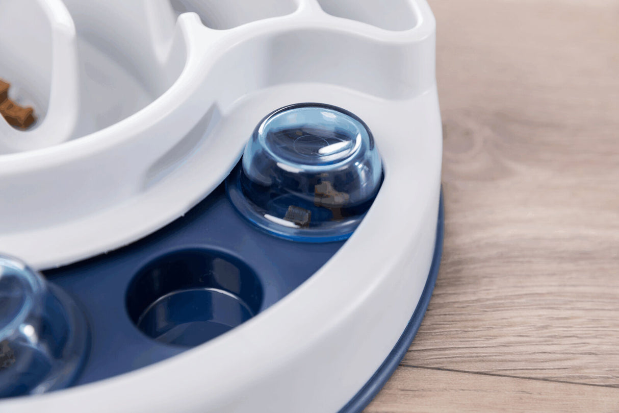 Plastikspielzeug mit blauen und weißen Elementen auf einem Tisch, teilweise bedeckt mit einer durchsichtigen blauen Kuppel.