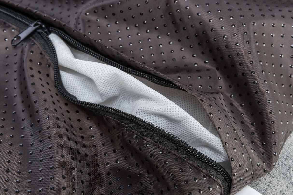 Schwarzer, gepunkteter Stoff mit Reißverschluss und sichtbarem weißem, perforiertem Futter.