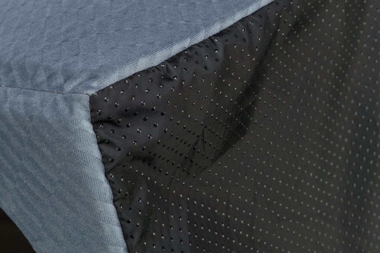 Ecke einer grauen gesteppten Oberfläche mit schwarzen, gepunkteten Seiten.