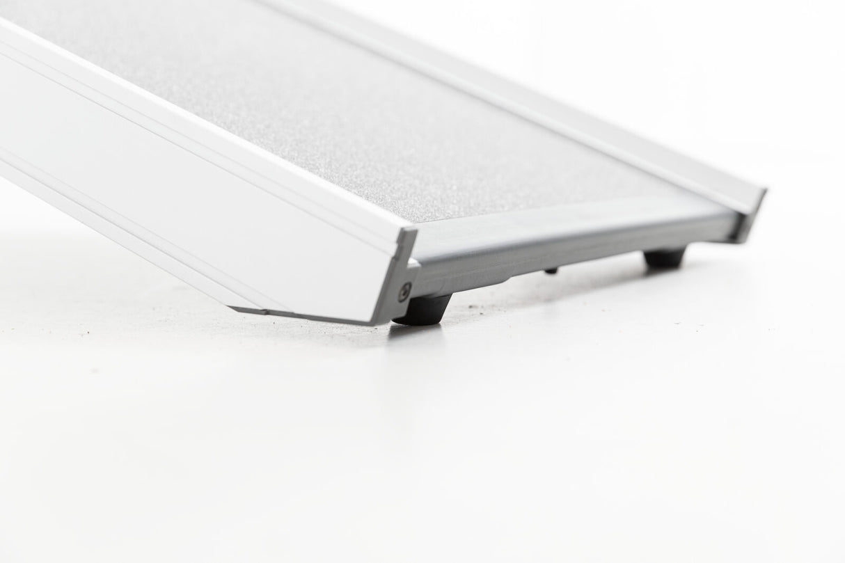 Graue Rampe mit Struktur auf der Oberfläche und seitlichen Begrenzungen auf heller Oberfläche.