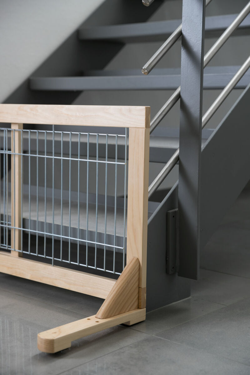 Holz- und Metallbarriere vor grauer Treppe installiert, silberne Gitterstäbe, glatter grauer Boden.