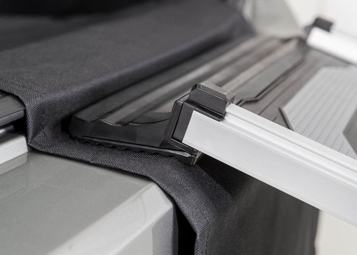 Schwarzer Stoff und silberne Metallschiene auf grauer Fläche, mit Kunststoff und Trittbrett-Elementen.