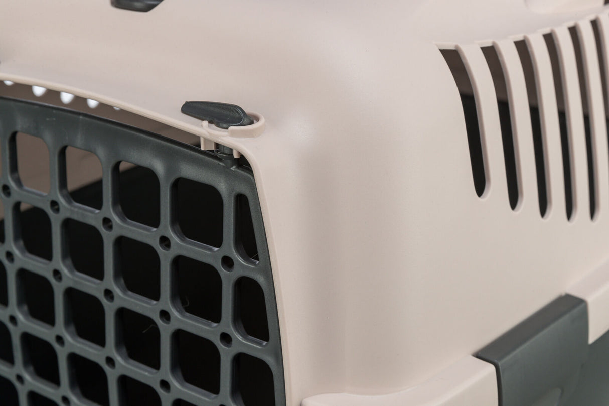 Beige Transportbox mit schwarzem Gitter und seitlichen Lüftungsschlitzen, robuste Bauweise erkennbar.