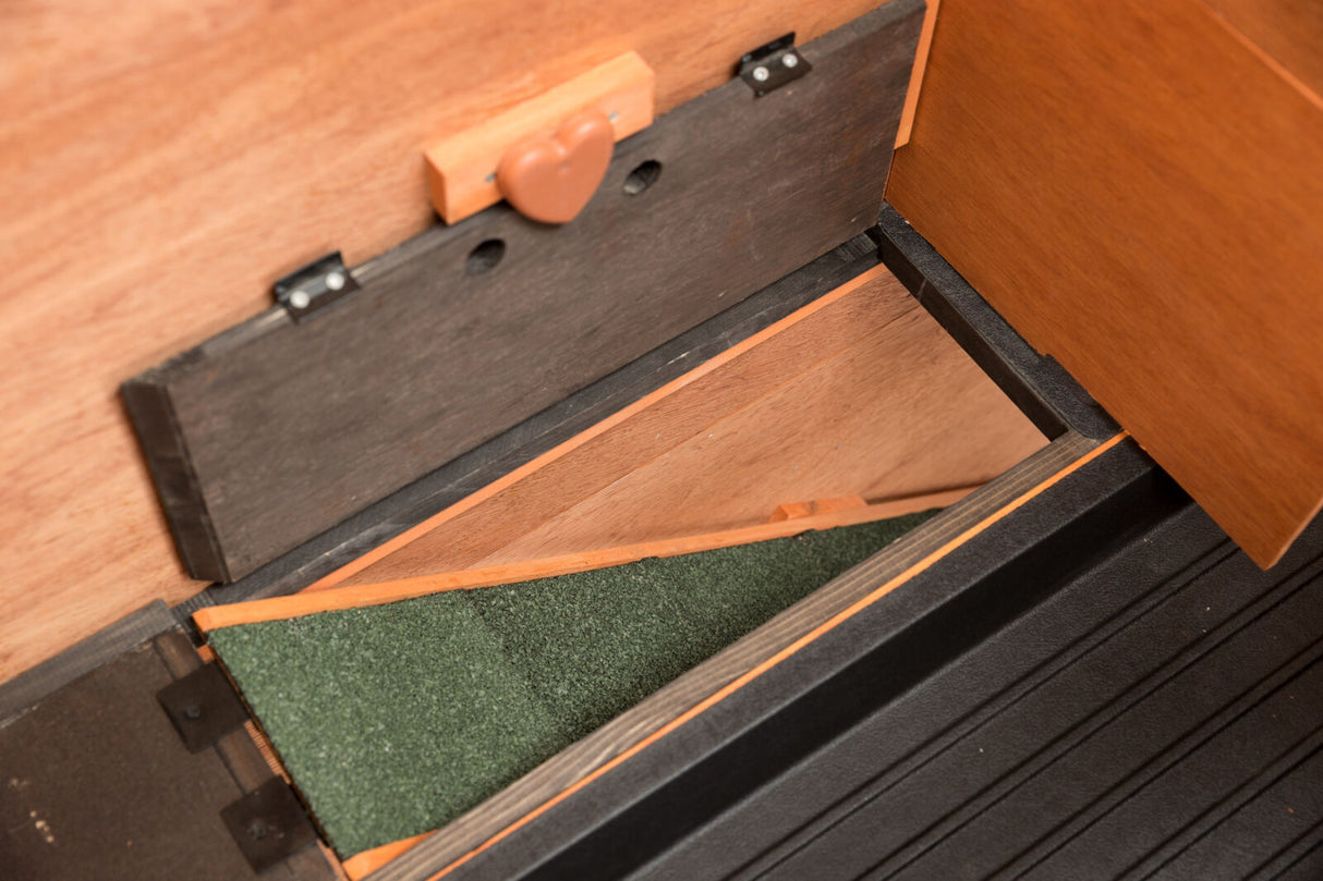 Holzstruktur mit einer schwarzen Klappe, grünem Stoff auf der Innenseite und einem herzförmigen Verschluss.