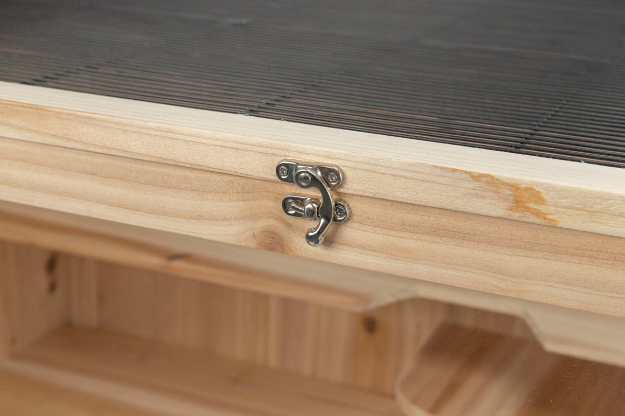 Holzschublade mit Metallverschluss, oberer Teil mit schwarzen Details, Holzmaserung sichtbar.