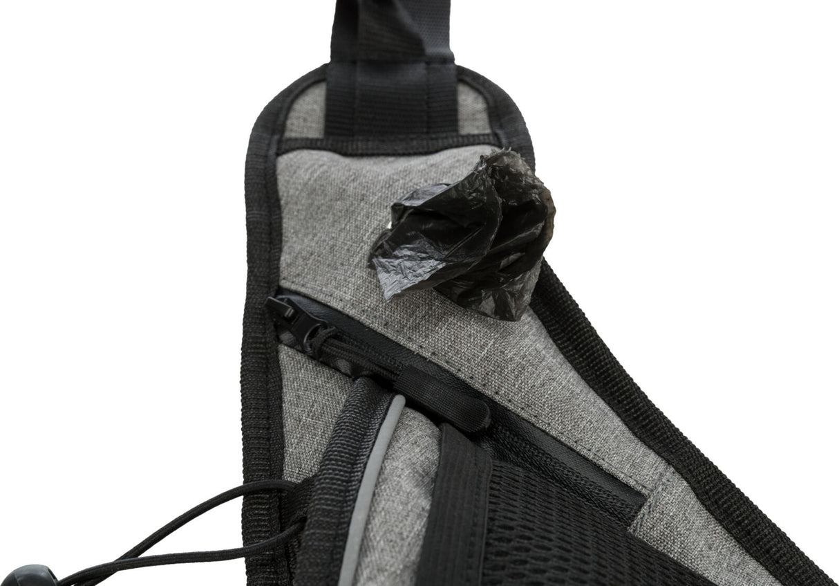 Nahaufnahme einer grauen Tasche mit schwarzem Reißverschluss und herausragendem schwarzen Beutel.