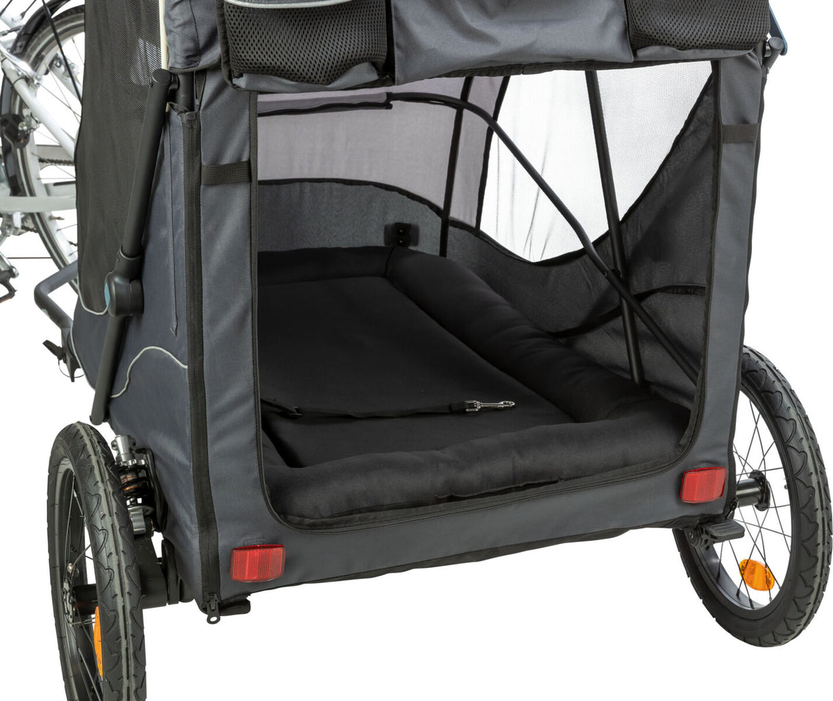 Ein schwarzer Fahrradanhänger mit zwei Rädern und offenem Innenraum, verbunden mit einem Fahrrad, Netzseiten und reflektierenden Rücklichtern.