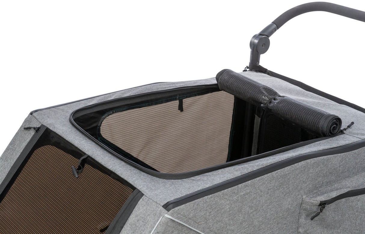 Grauer Fahrradanhänger mit geöffnetem, netzbespanntem Dach, schwarzen Akzenten und klappbarem Griff.