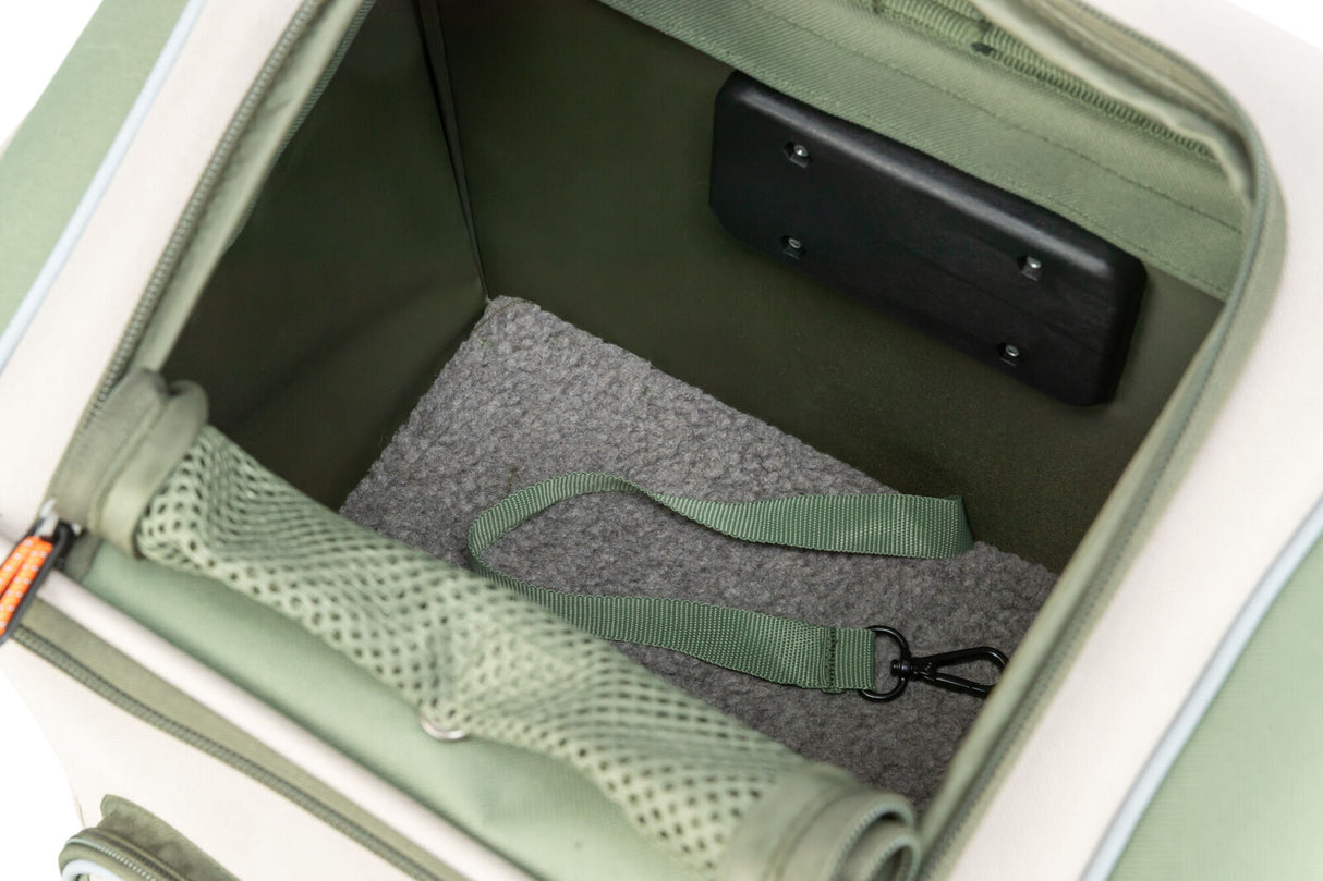Geöffneter, grüner Rucksack mit grauem Fleeceboden und einem grünen Gurt mit Metallkarabiner innen.