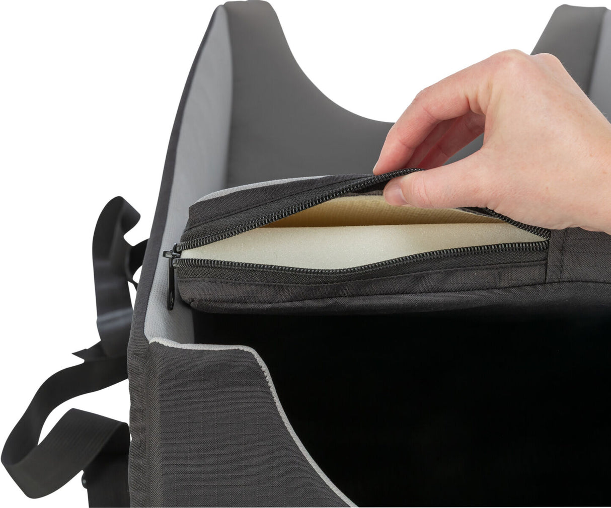 Eine Hand öffnet einen Reißverschluss an einer grauen Tasche mit weichem, sichtbarem Polster im Inneren.