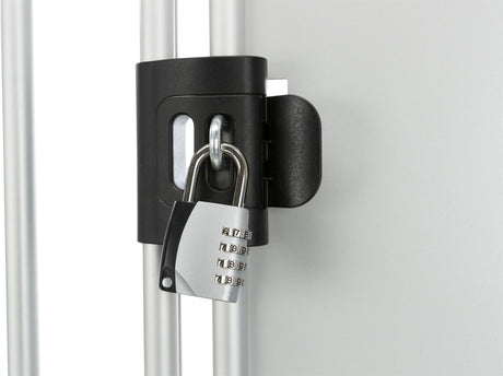 Schwarzes Vorhängeschloss mit Zahlenkombination sichert Metallstäbe an einer grauen Oberfläche.