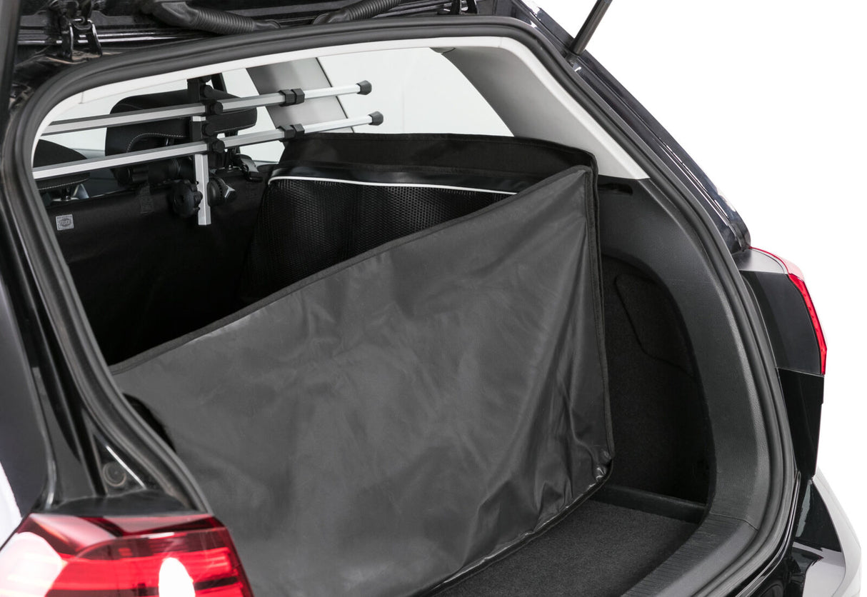 Ein geöffneter Kofferraum eines schwarzen Autos zeigt eine schwarze Schutztasche und ein Schutzgitter.