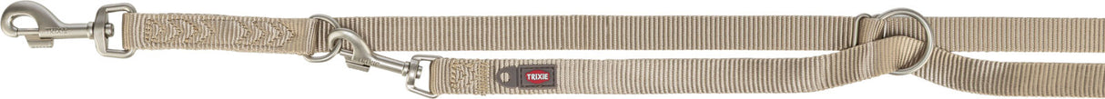Beige verstellbare Hundeleine mit Metallbeschlägen und einem Ring, Markierungen und Logo "TRIXIE" sichtbar.