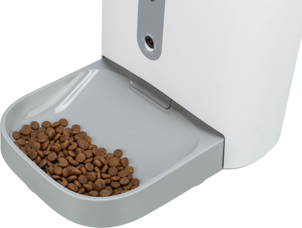 Automatischer Futterautomat mit grau-weißem Design, Napf mit braunen Pellets gefüllt.