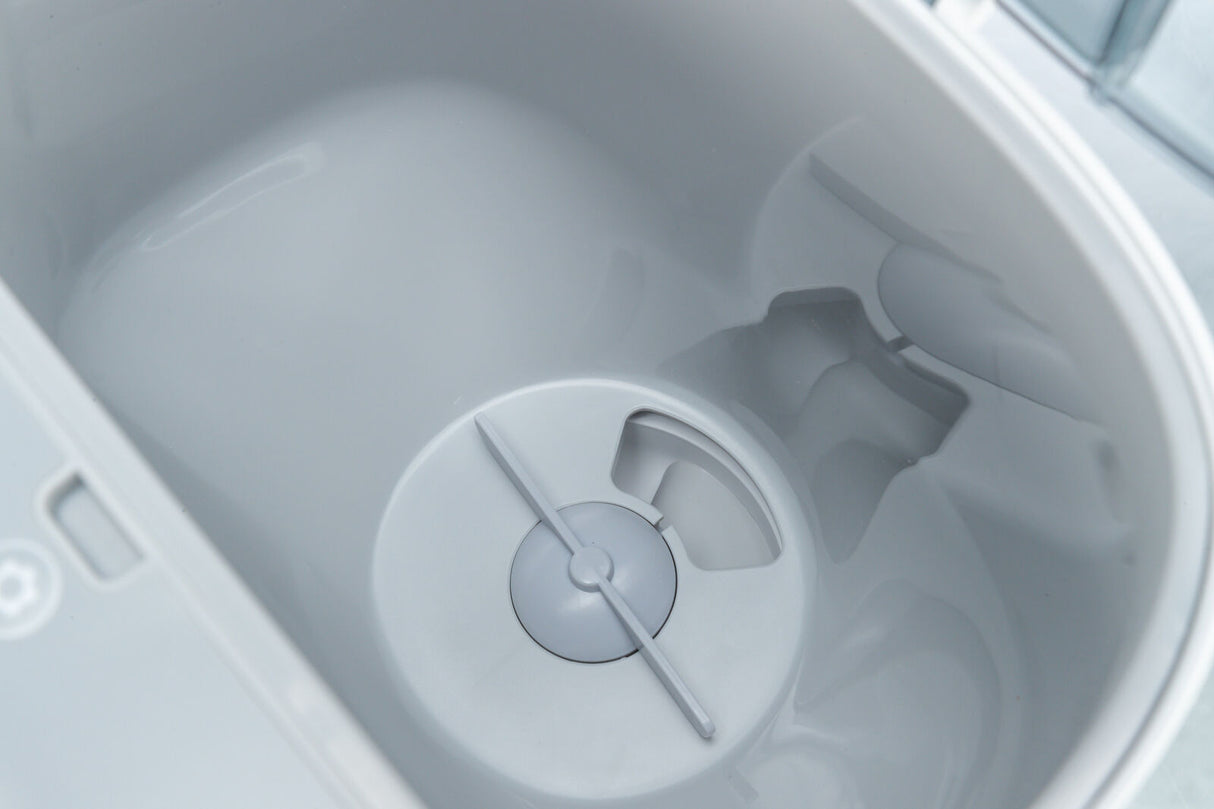 Grauer, runder Behälter mit zentraler Öffnung und symmetrischem Design, glänzende Oberfläche, Seitenansicht.