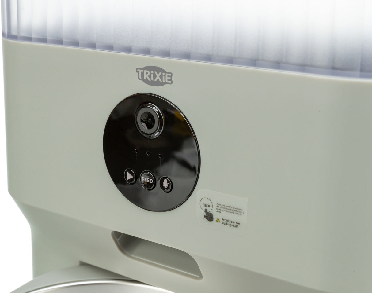 Automatischer Futterautomat mit weißem Gehäuse und schwarzem Bedienfeld mit Kamera, Mikrofon und Feed-Taste.