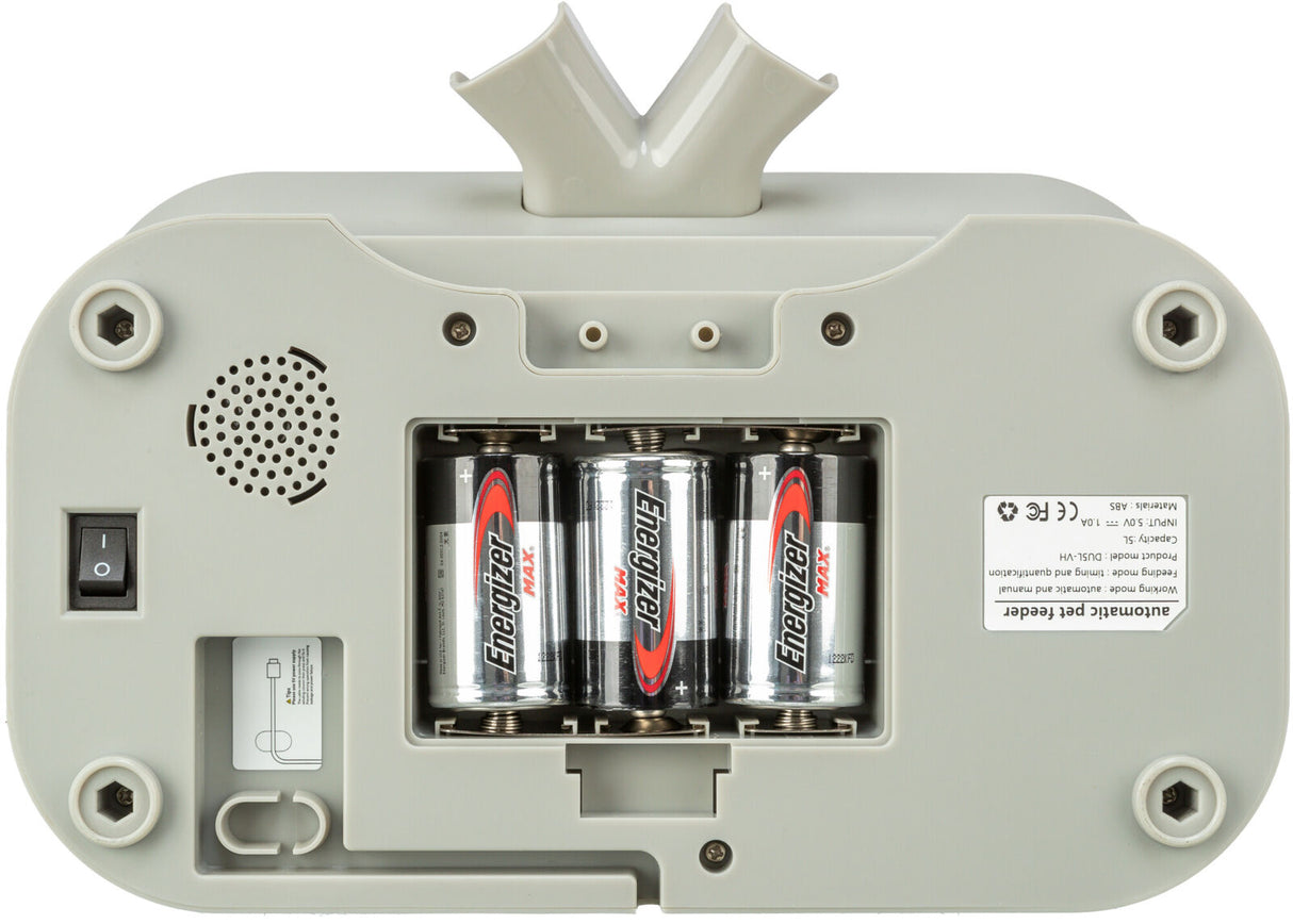 Unterseite eines Geräts mit geöffnetem Batteriefach, das drei Energizer-Batterien enthält, Kippschalter und Lautsprechergitter sichtbar.