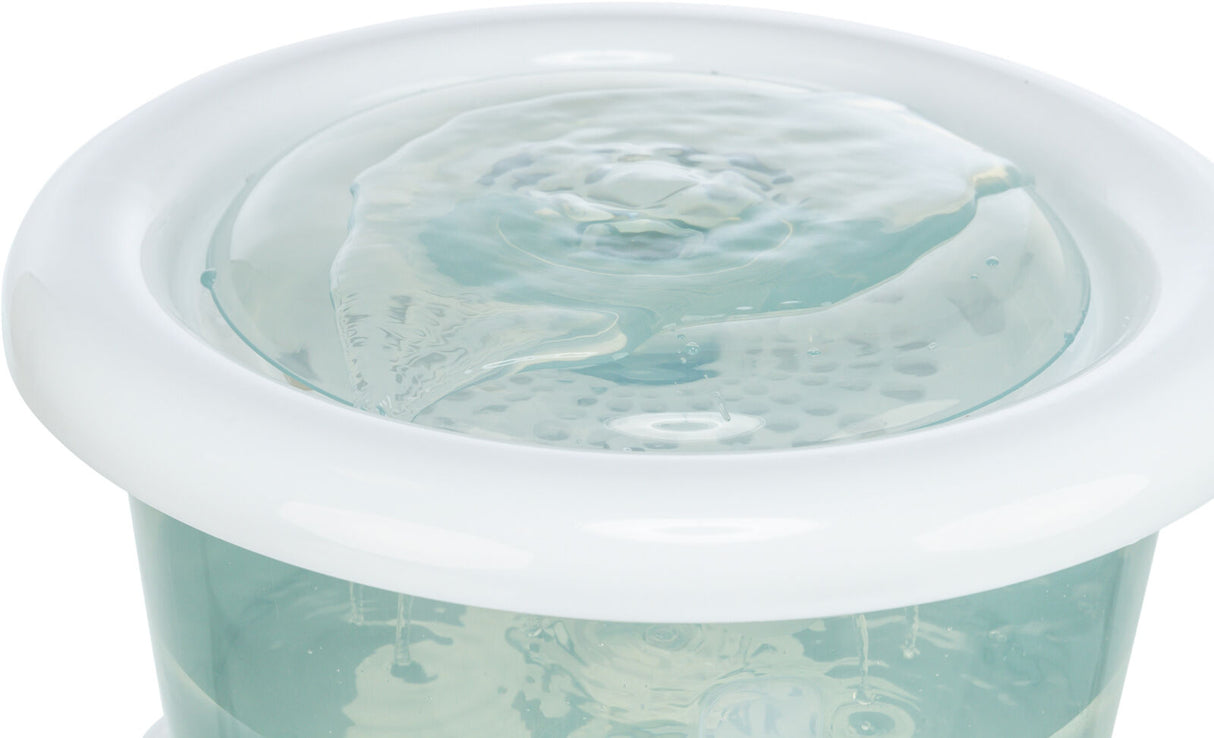 Transparenter Wasserbehälter mit blauer Flüssigkeit und weißem Rand, Oberfläche zeigt konzentrische Bewegungen.