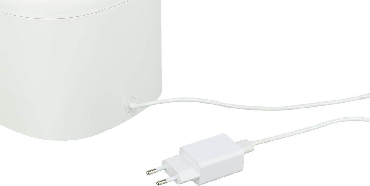 Weißes elektrisches Gerät mit angeschlossenem Kabel und einem weißen Stecker im europäischen Stil.