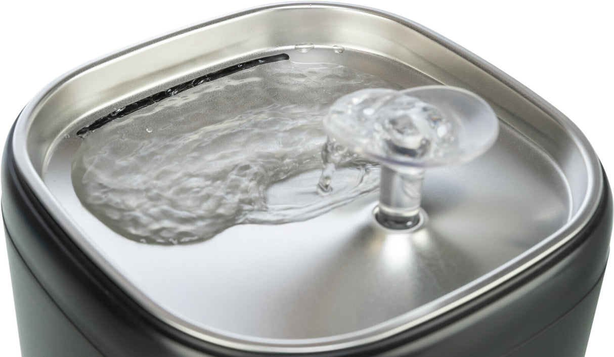 Quadratischer Wasserspender aus Metall mit einer transparenten Kuppel, aus der Wasser fließt.
