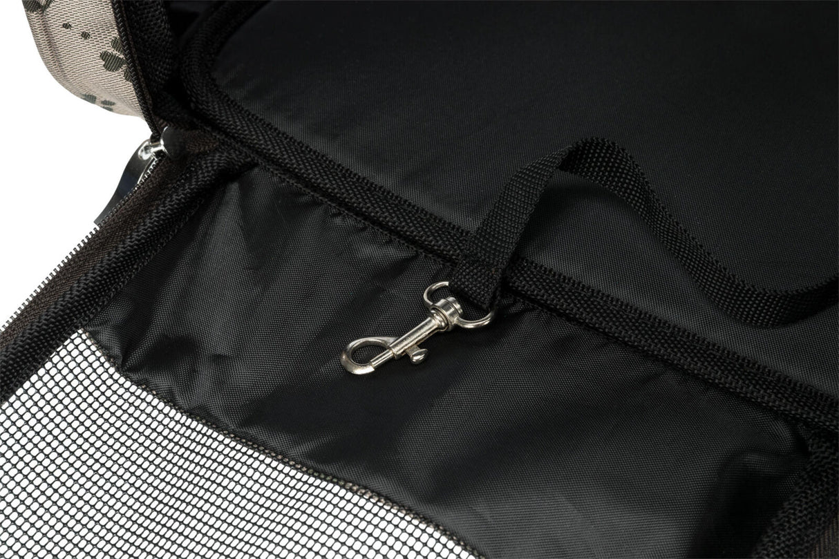 Schwarzer Stoff mit Netzgewebe und Karabinerhaken, umgeben von hell gemustertem Material.