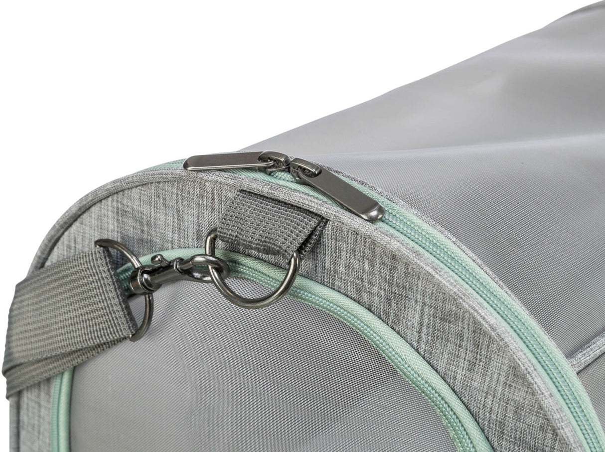 Graue Tasche mit grünem Reißverschluss und Metallschnallen, Nahaufnahme eines Teils der Tasche mit strukturiertem Stoff.