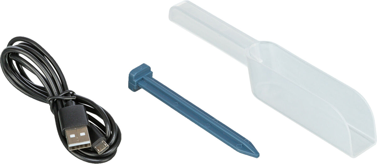 Schwarzes USB-Kabel, transparenter Messlöffel und blauer Pflock auf weißem Hintergrund.