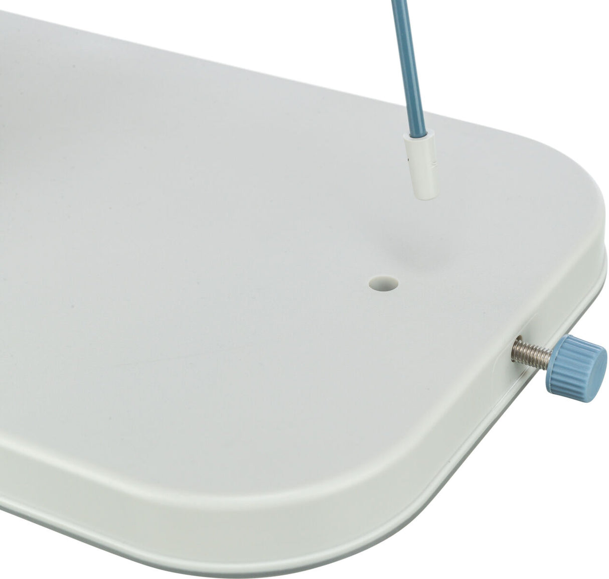 Weiße rechteckige Platte mit abgerundeten Ecken, blauem Drehknopf und zwei senkrechten Stangenlöchern.