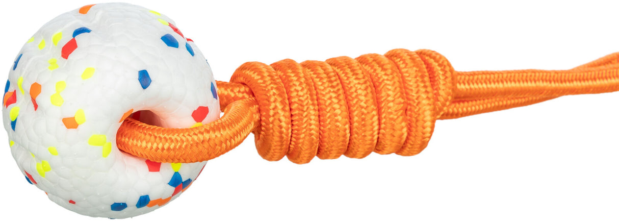 Weißer Ball mit bunten Punkten, durch den ein orangefarbenes Seil geführt ist.