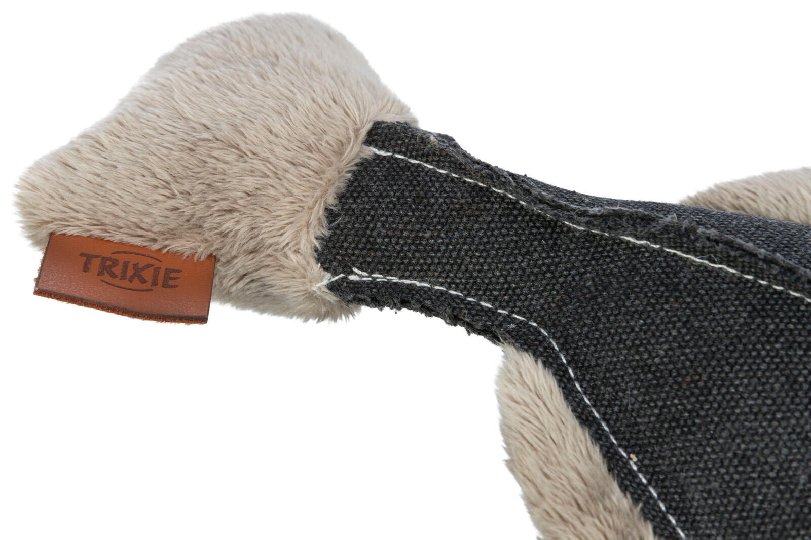 Ein Hundespielzeug aus flauschigem, grauem Stoff mit dunkelgrauem Textil und einem braunen Etikett mit der Aufschrift "TRIXIE".