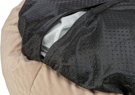 Schwarzes, gepunktetes Material mit Reißverschluss über beige Textur, darunter weißes Füllmaterial sichtbar.