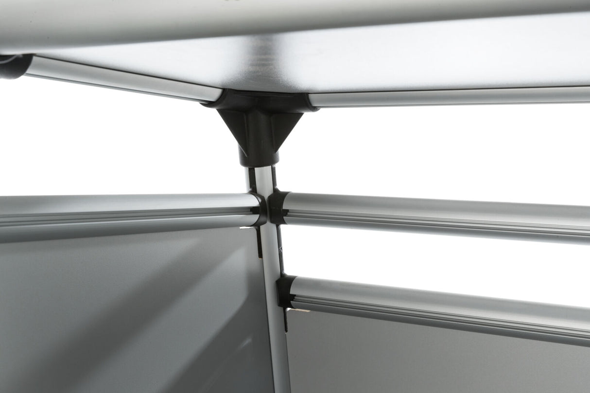 Metallene, silberne Struktur aus Rohren und Verbindungsstücken, die ineinander gesteckt sind, vor weißem Hintergrund.