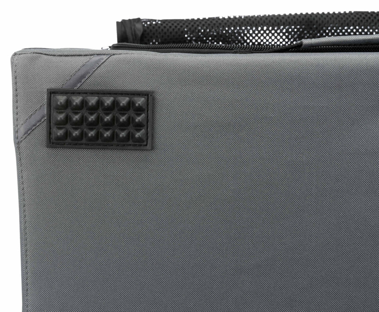 Graues Textilmaterial mit rechteckigem, genopptem, schwarzen Aufnäher und schwarzer Netztasche oben.