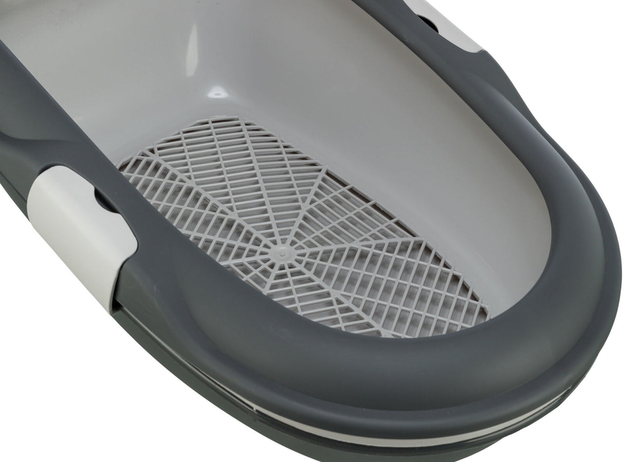 Graue, ovale Katzentoilette mit Gitterboden in einem weißen Innenbereich, keine Haube sichtbar.