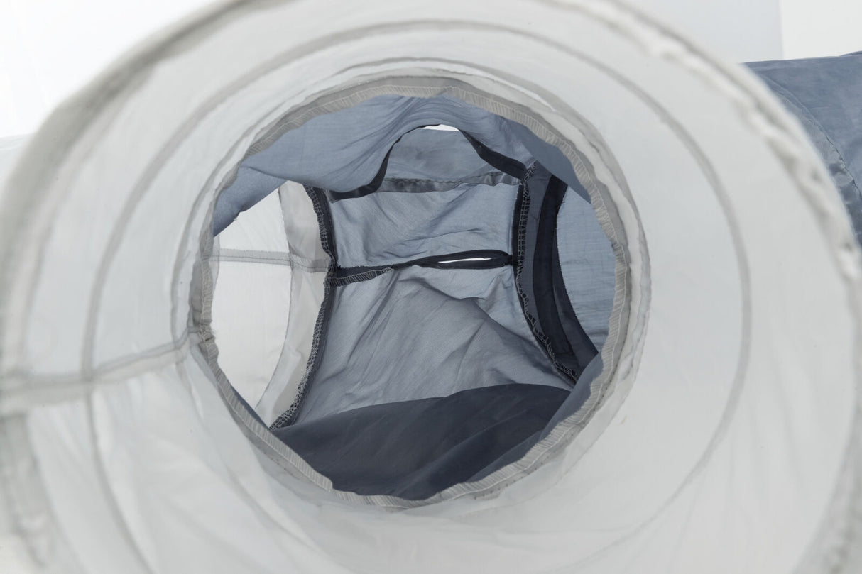 Ein grauer Stofftunnel mit transparenten Abschnitten zieht sich in die Tiefe, scheinbar für Spiel- oder Transportzwecke.