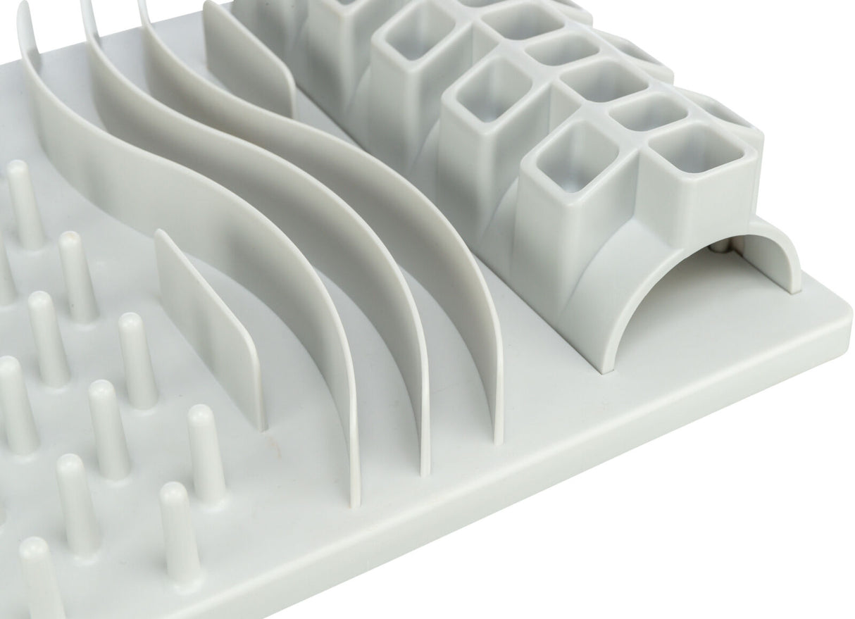 Weiße Kunststoffmatte mit erhobenen Wellen, zylindrischen Stiften und quadratischen Vertiefungen.