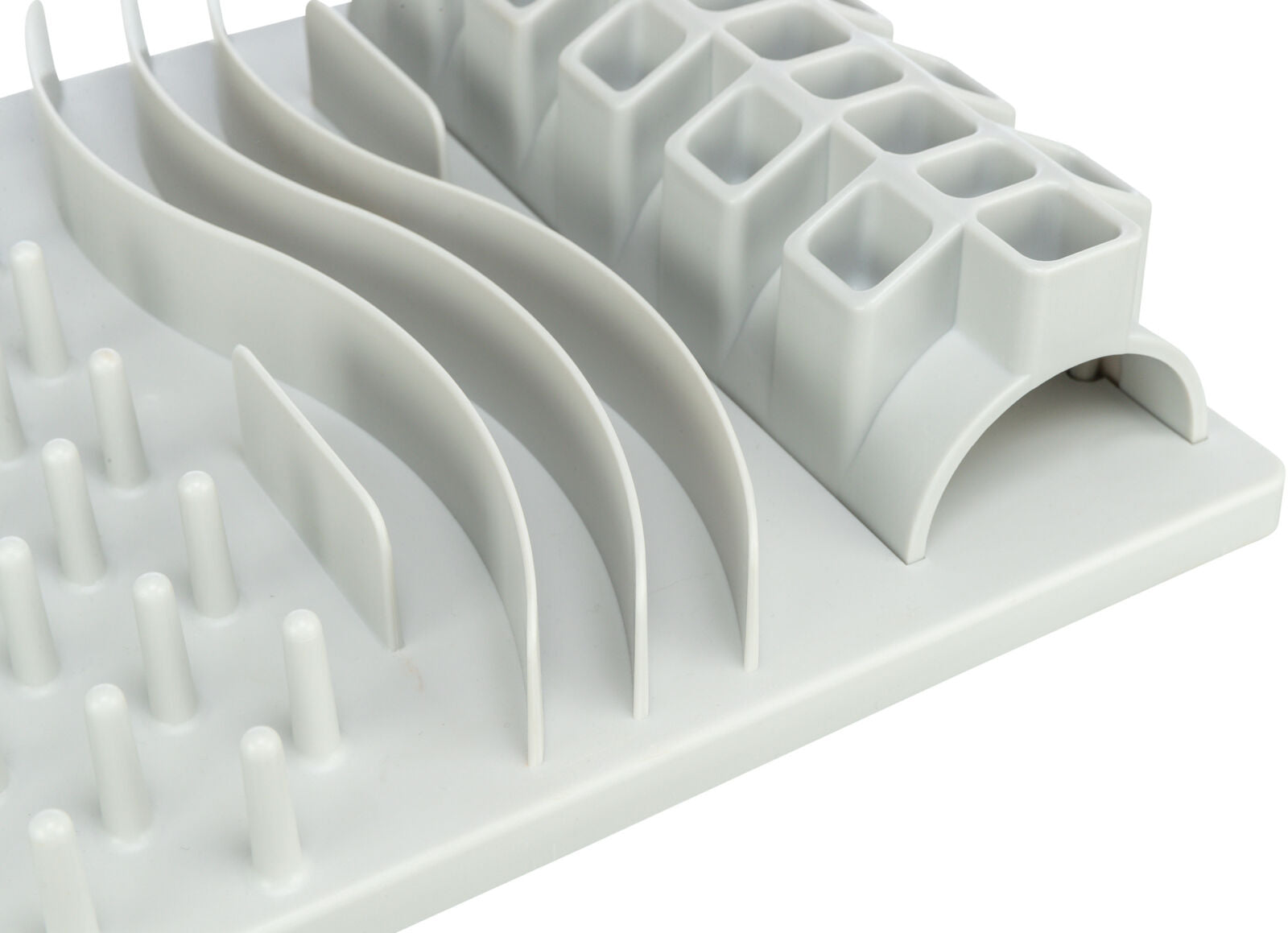 Weiße Kunststoffmatte mit erhobenen Wellen, zylindrischen Stiften und quadratischen Vertiefungen.