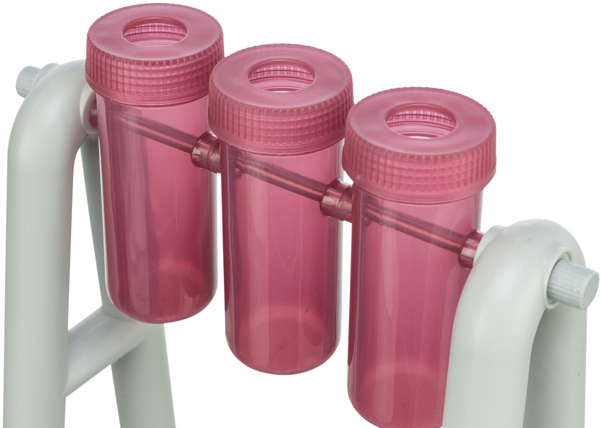 Drei rosa Kunststoffröhren mit Schraubverschlüssen sind an einem weißen Gestell befestigt.