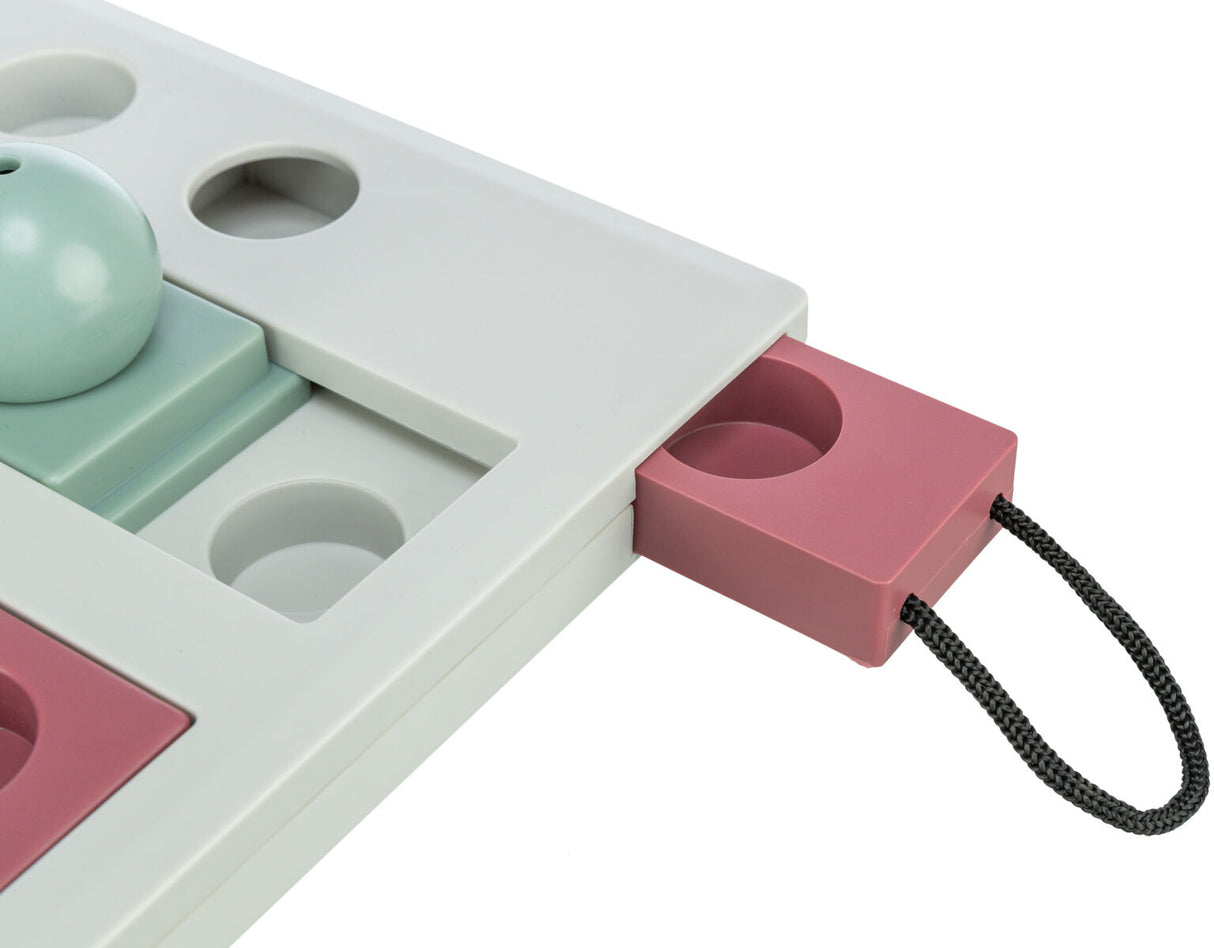 Spielzeug mit Schiebemechanismus, graue und rosafarbene Teile, schwarzer Griff, runde Vertiefungen sichtbar.