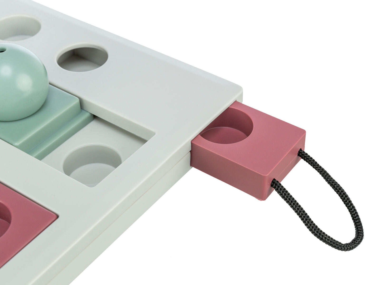 Spielzeug mit Schiebemechanismus, graue und rosafarbene Teile, schwarzer Griff, runde Vertiefungen sichtbar.